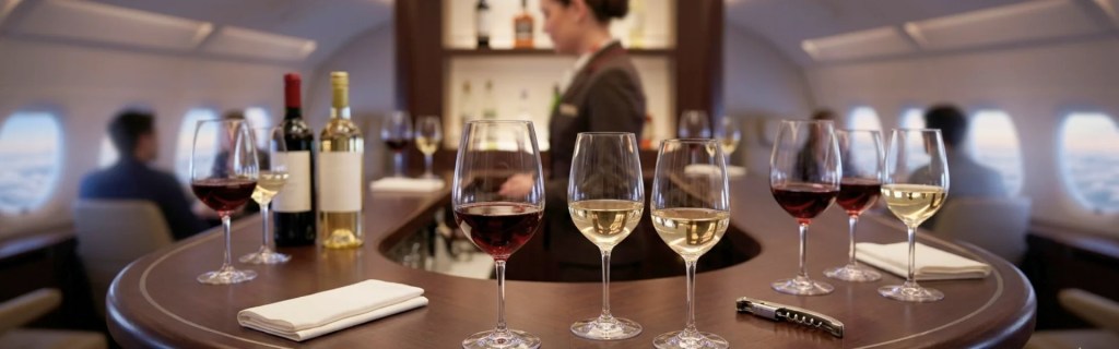 A well-curated presentation of red and white wines in an exclusive airplane lounge, exploring the physics of why wine tastes different on a plane.